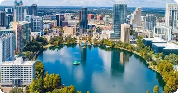 Aerial view of Lake Eola in downtown Orlando, Florida, surrounded by high-rise commercial buildings and city skyline.