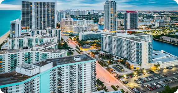 Aerial view of high-rise commercial buildings and beachfront real estate along the Sunny Isles Beach coastline in Florida.