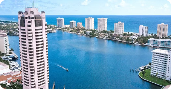 Aerial view of high-rise commercial buildings and luxury waterfront properties along Boca Raton Lake and the Atlantic coastline in Florida.