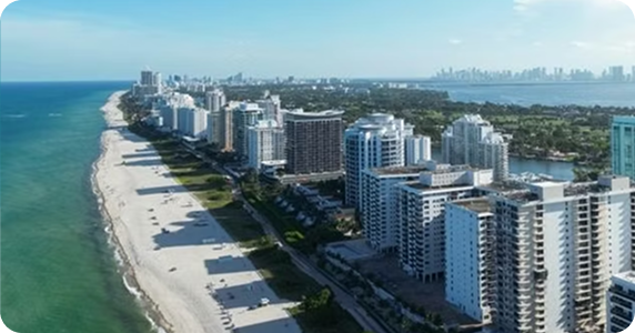 Aerial view of Miami high-rise beachfront properties and commercial real estate along the Atlantic coastline.