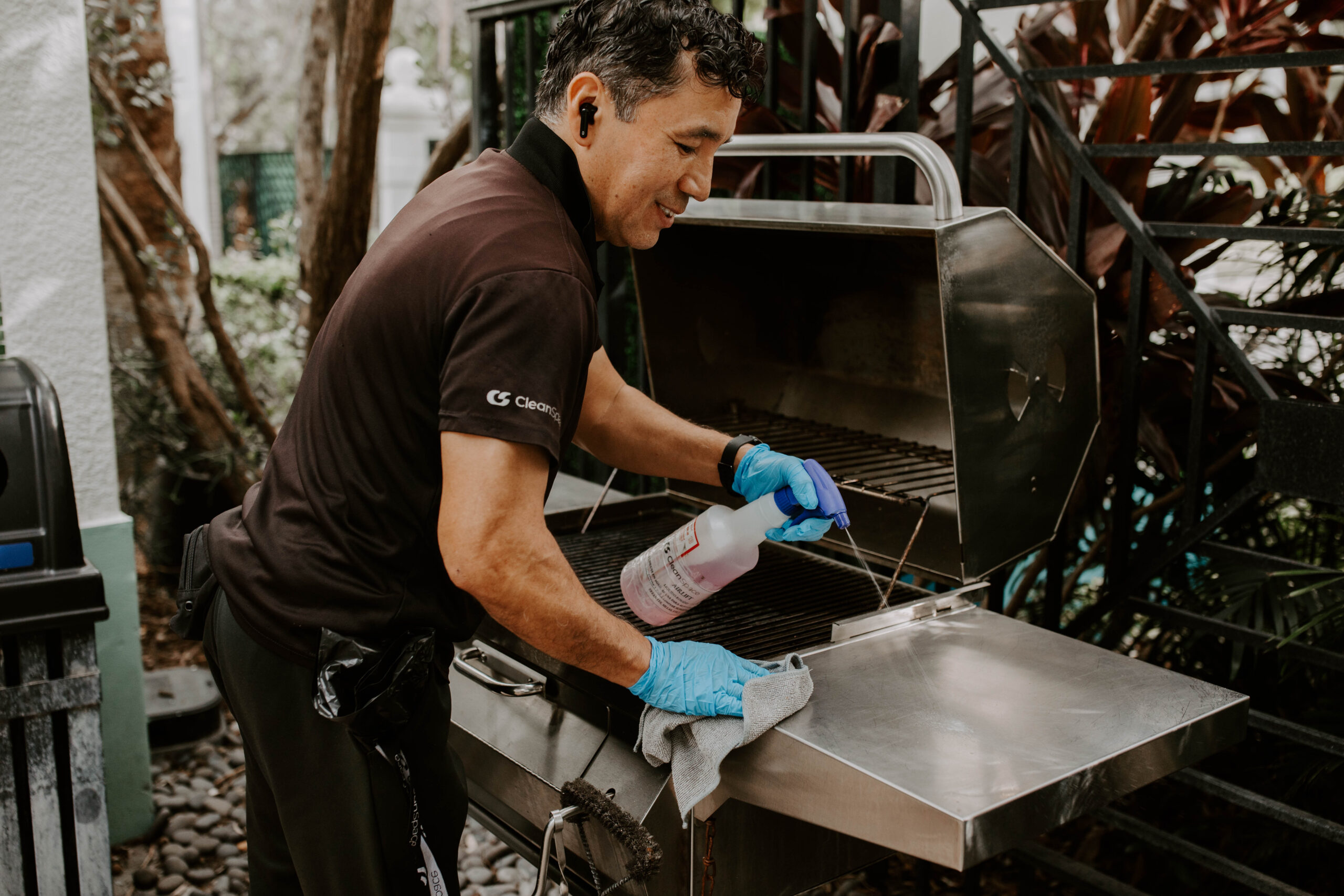 Clean Space cleaner sanitizing a BBQ grill at a Florida apartment amenity area