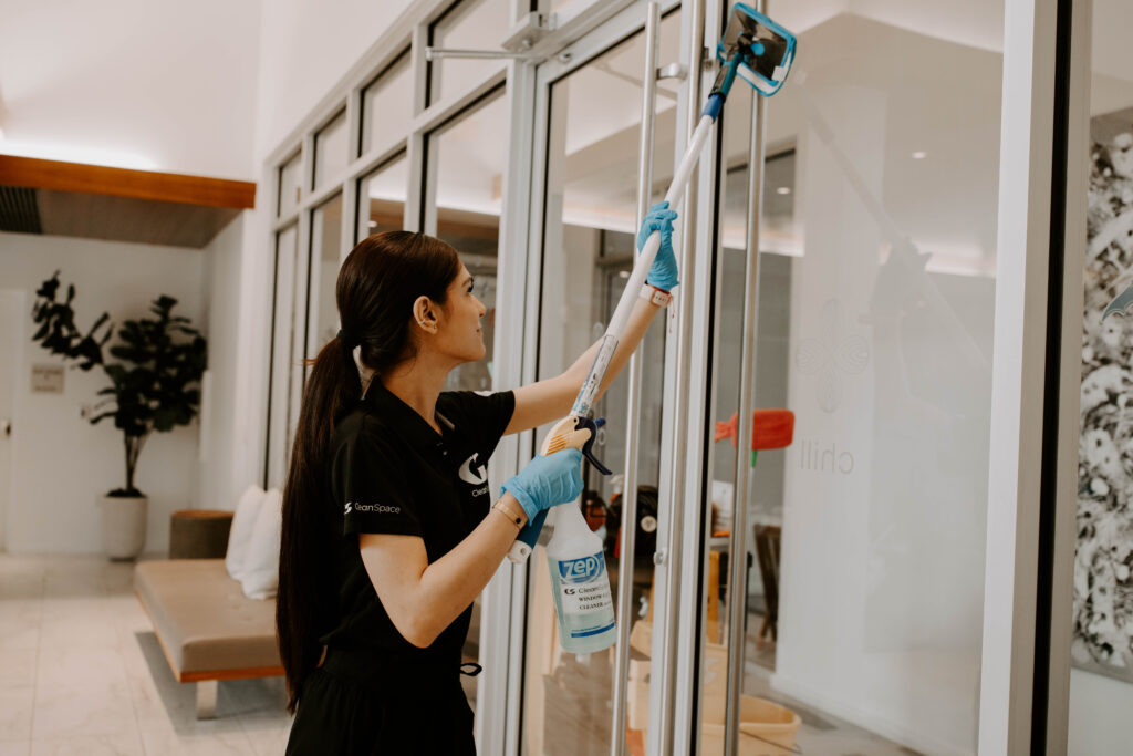 Clean Space cleaner washing interior lobby windows in a Florida building