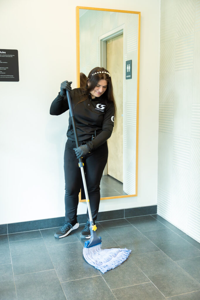 Clean Space janitorial staff wet mopping a restroom hallway floor in Florida