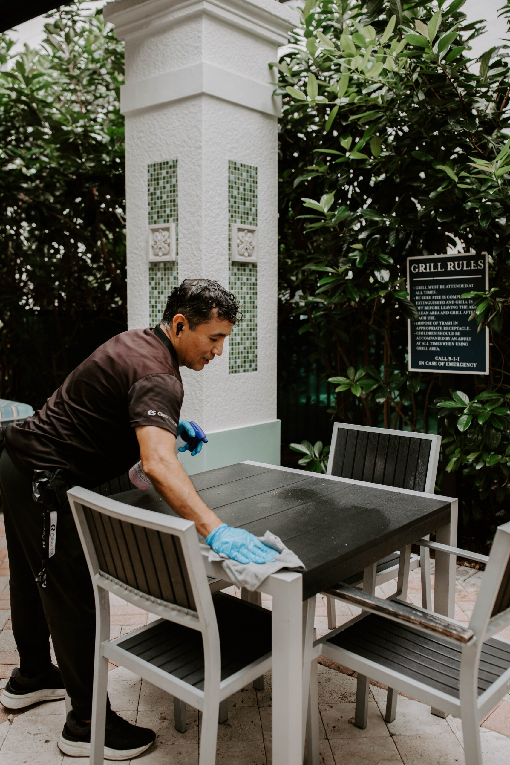 Clean Space cleaner wiping a patio table in a Florida courtyard